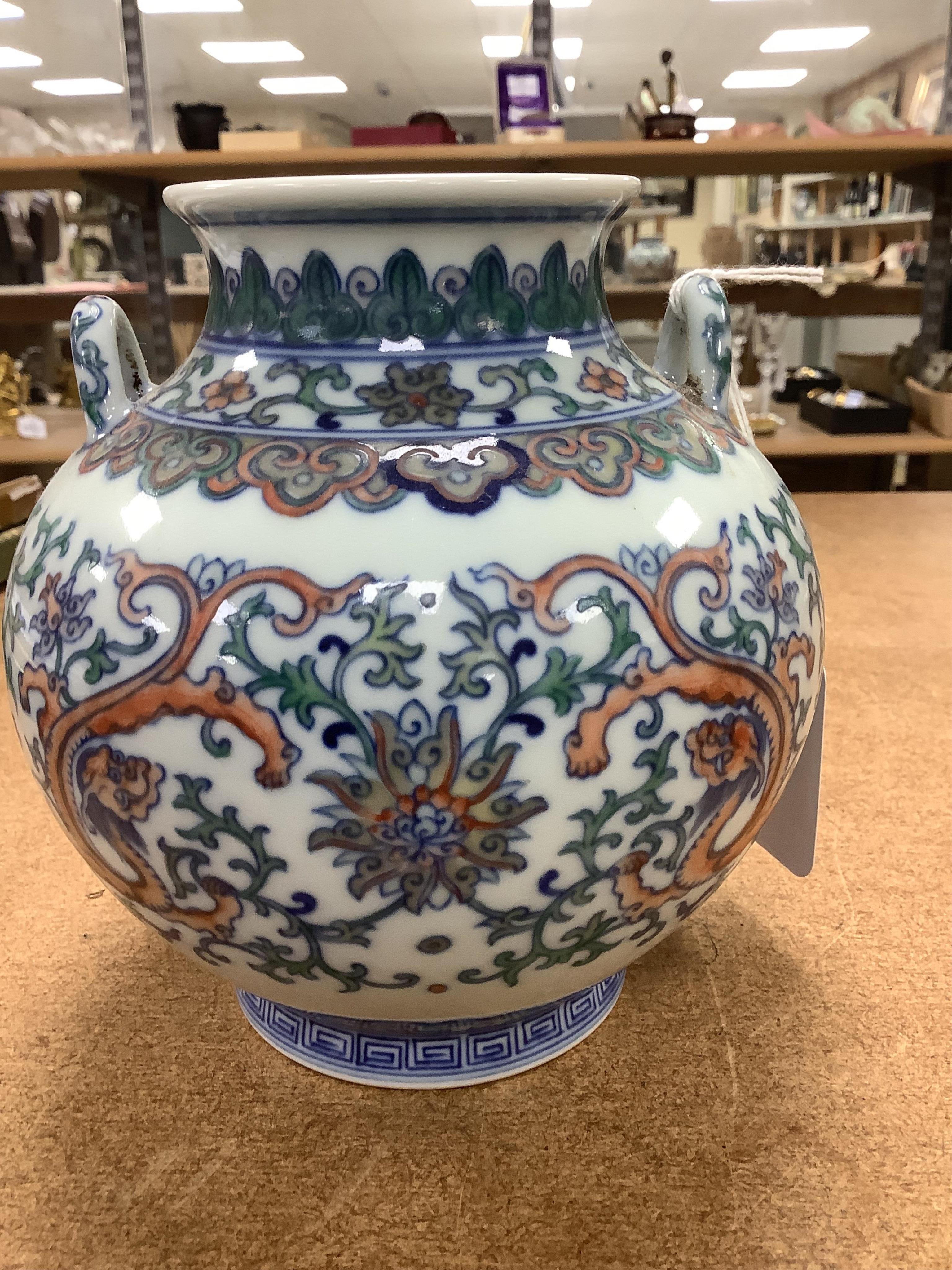 A pair of Chinese porcelain doucai twin handled ‘dragon’ jars, 14cm high. Condition - good
